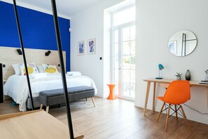 A modern bedroom with a bed, a desk, and a chair. - Vrbo Property (NIMES)