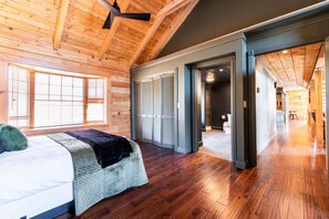 A bedroom with a bed, a window, and a wooden ceiling. - Secluded 51-Acre Retreat | 2 Cabins, Pond & Garden (Henryville)
