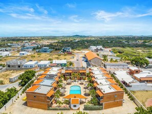 Ein Hotelkomplex mit mehreren Gebäuden, einem Schwimmbad und Blick auf die umliegende Landschaft.