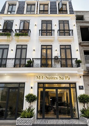 Un hotel de varios pisos con un letrero que dice 'MT Suites Sa Pa'.