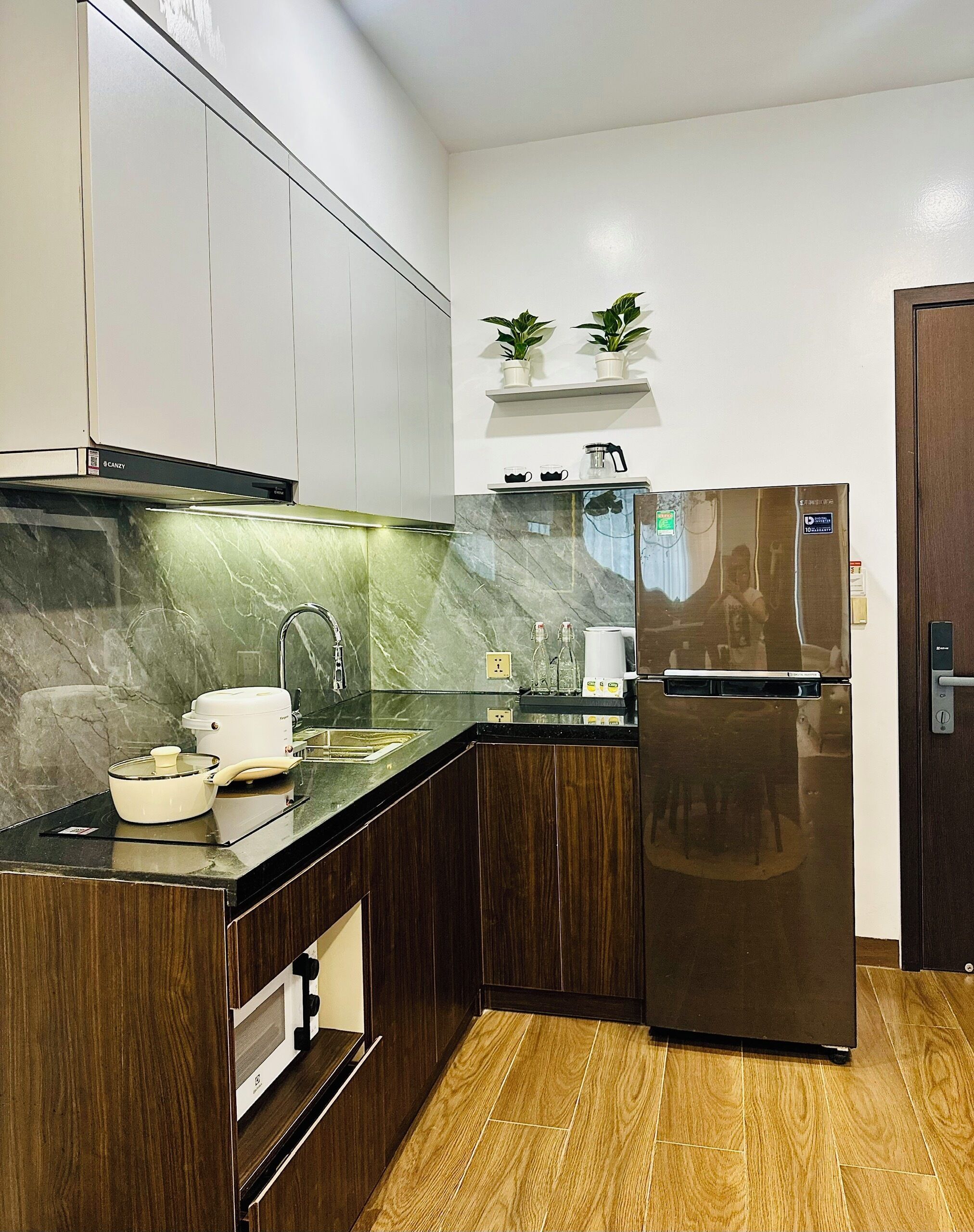 A modern kitchen with a built-in refrigerator, a microwave, and a stove.