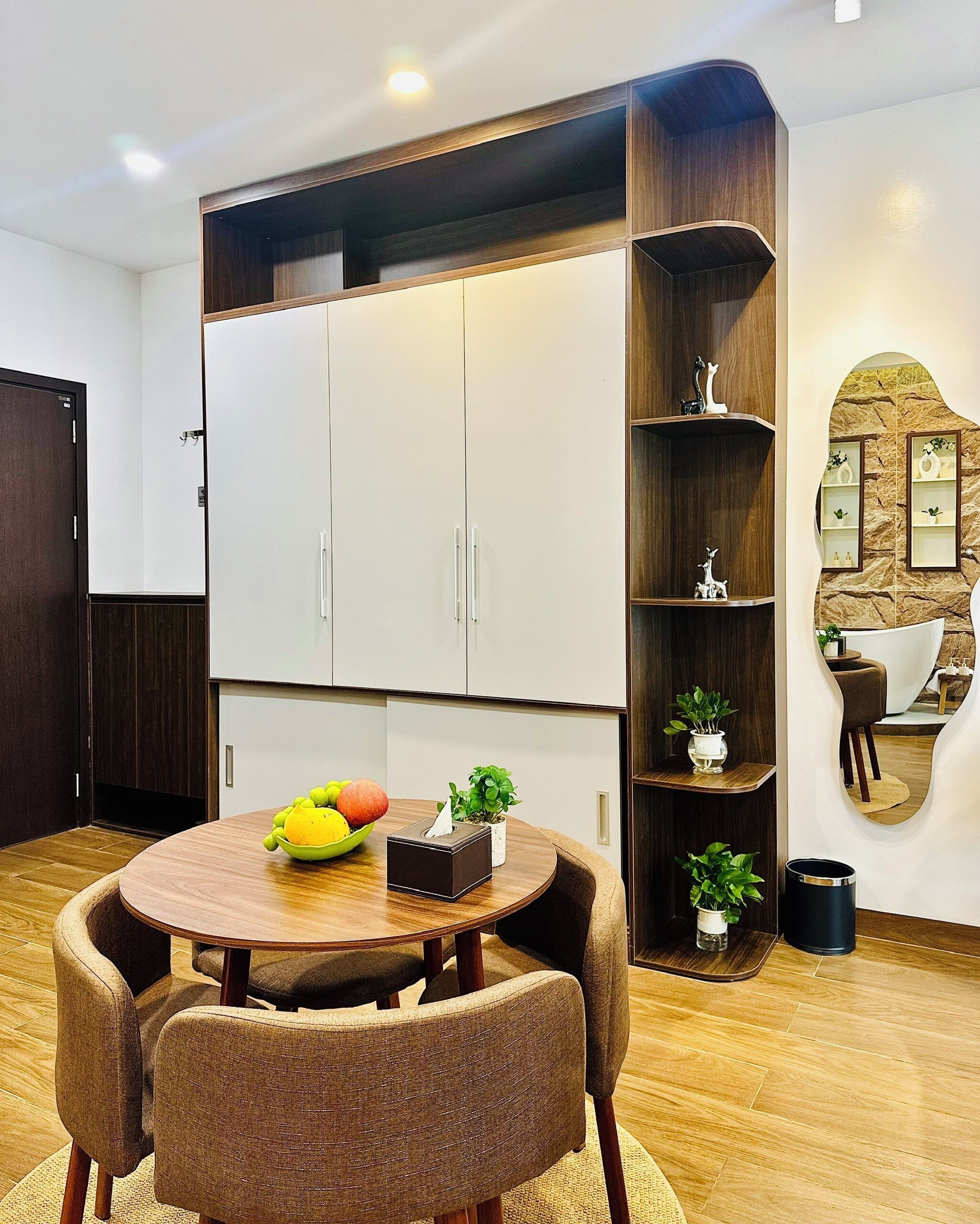 A dining area with a round table, chairs, a fruit bowl, and a tissue box.