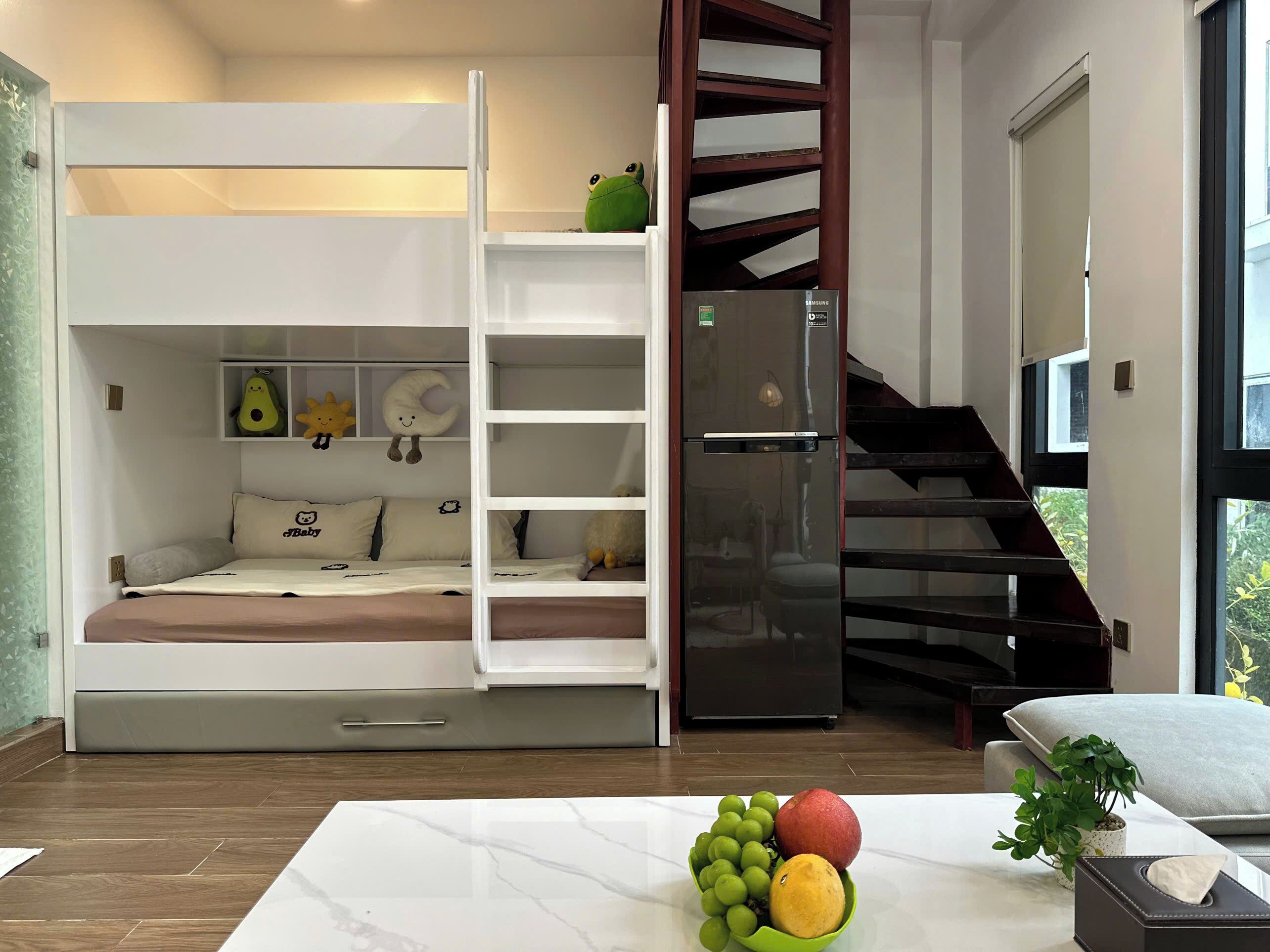 Ein Schlafzimmer mit einem Etagenbett, einem Einbauschrank, einer Wendeltreppe und einem Esstisch mit Früchten.