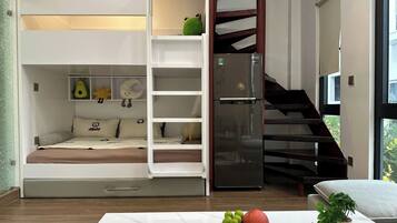 Ein Schlafzimmer mit einem Etagenbett, einem Einbauschrank, einer Wendeltreppe und einem Esstisch mit Früchten.