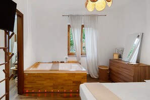 A modern bathroom with a wooden bathtub, a wooden vanity, a mirror, and a window with curtains.