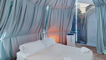A tent-style room with a bed, a heater, and a window.