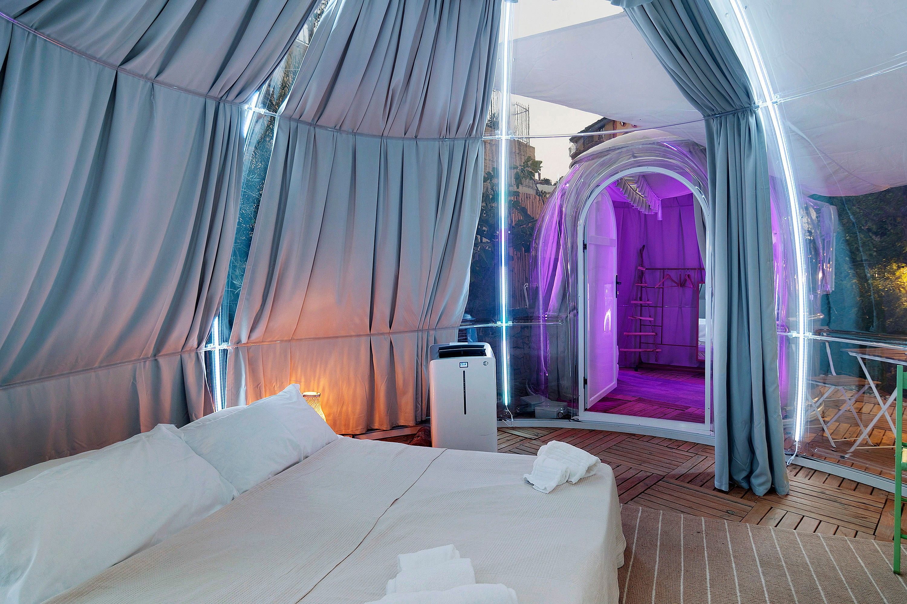A bedroom with a large bed, a window, and a view of an outdoor area.