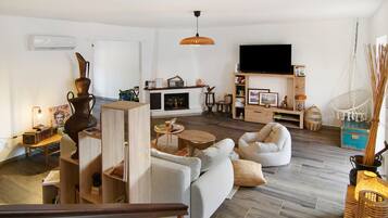 A modern living room with a fireplace, seating area, and a television.