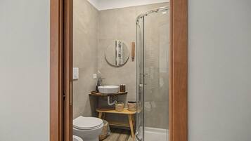 Ein kleines Badezimmer mit Toilette, Waschbecken und Duschkabine.
