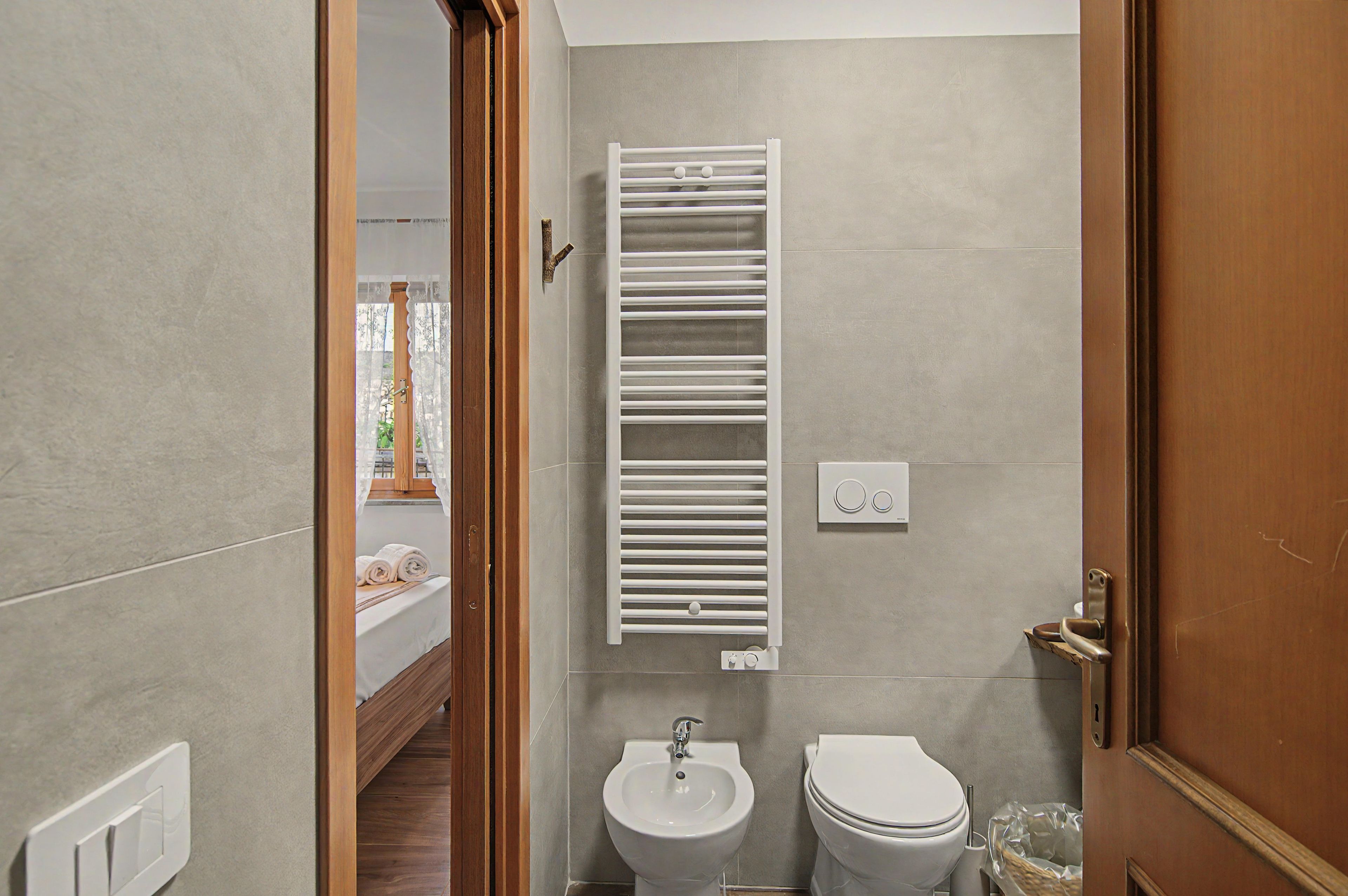 Un baño con una bañera blanca, un inodoro y un perchero para toallas.