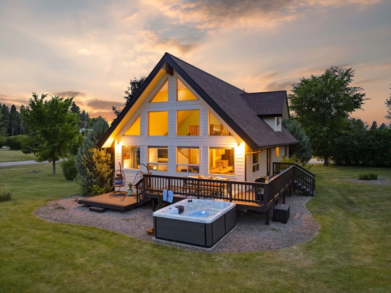 A two-story house with a deck and hot tub.