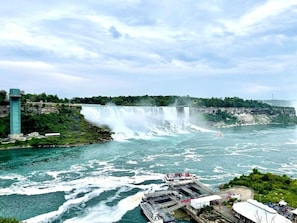 A large waterfall with a viewing platform and a tall tower. - Serenity by the Falls: Modern 2 Bedroom Hideaway (Niagara Falls)