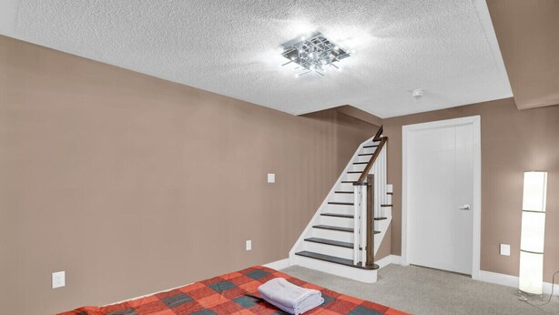 A bedroom with a bed, a staircase, and a door. - Stylish Mississauga Lower Unit BBQ Yard Paradise (Mississauga)
