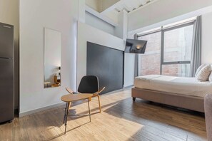 A modern bedroom with a bed, a chair, a desk, and a large window. - JA 303 Minimalist Comfort Near Bellas Artes (Centro)