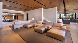 Ein modernes Wohnzimmer mit einer Eckcouch, einem Couchtisch und einer Treppe.