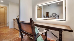 A bedroom with a large mirror, a wooden desk, a chair, a bed, and a wardrobe. - Hacienda Beach Club 1100 (Cabo San Lucas)