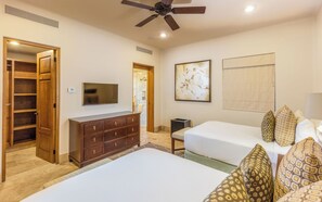 A hotel room with a bed, a dresser, a television, a ceiling fan, and a shower. - Diamante Golf Villa 22 (Cabo San Lucas)
