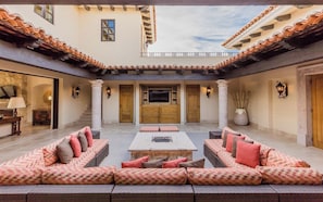 A courtyard with a central seating area, a television, and a fireplace. - Diamante Golf Villa 22 (Cabo San Lucas)