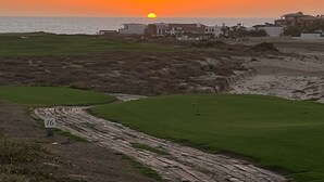 A coastal landscape with a golf course, buildings, and a sunset. - Diamante Golf Villa 39 (Cabo San Lucas)