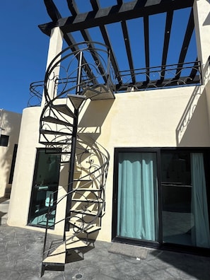 A spiral staircase with a metal railing leading to a balcony with a black metal frame. - Grand Villa Famlee - multi-family rental sleeps 16 (Cabo San Lucas)