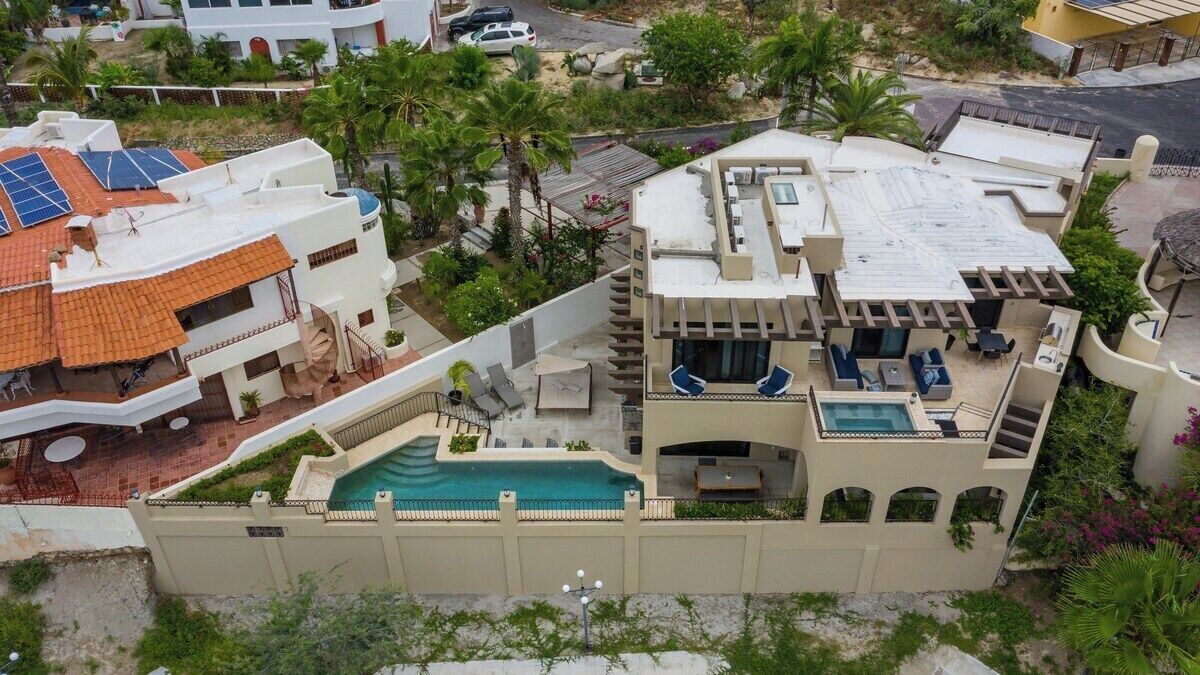 A residential property with a swimming pool, outdoor seating, and solar panels.