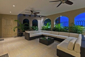 A spacious living area with a sectional sofa, a coffee table, and potted plants. - Marbella lane - Stylish Private Villa OceanViews (Cabo San Lucas)