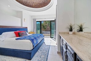 A bedroom with a large bed, a bathroom with a marble countertop, and a view of the outdoors. - Marbella Lane PrimeVilla n Modern Home Comfort (Cabo San Lucas)