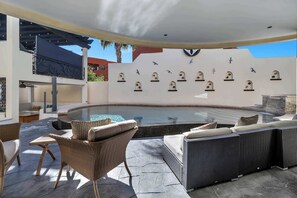 An outdoor pool area with a hot tub, wicker furniture, and decorative wall-mounted bird sculptures. - Marbella Lane PrimeVilla n Modern Home Comfort (Cabo San Lucas)