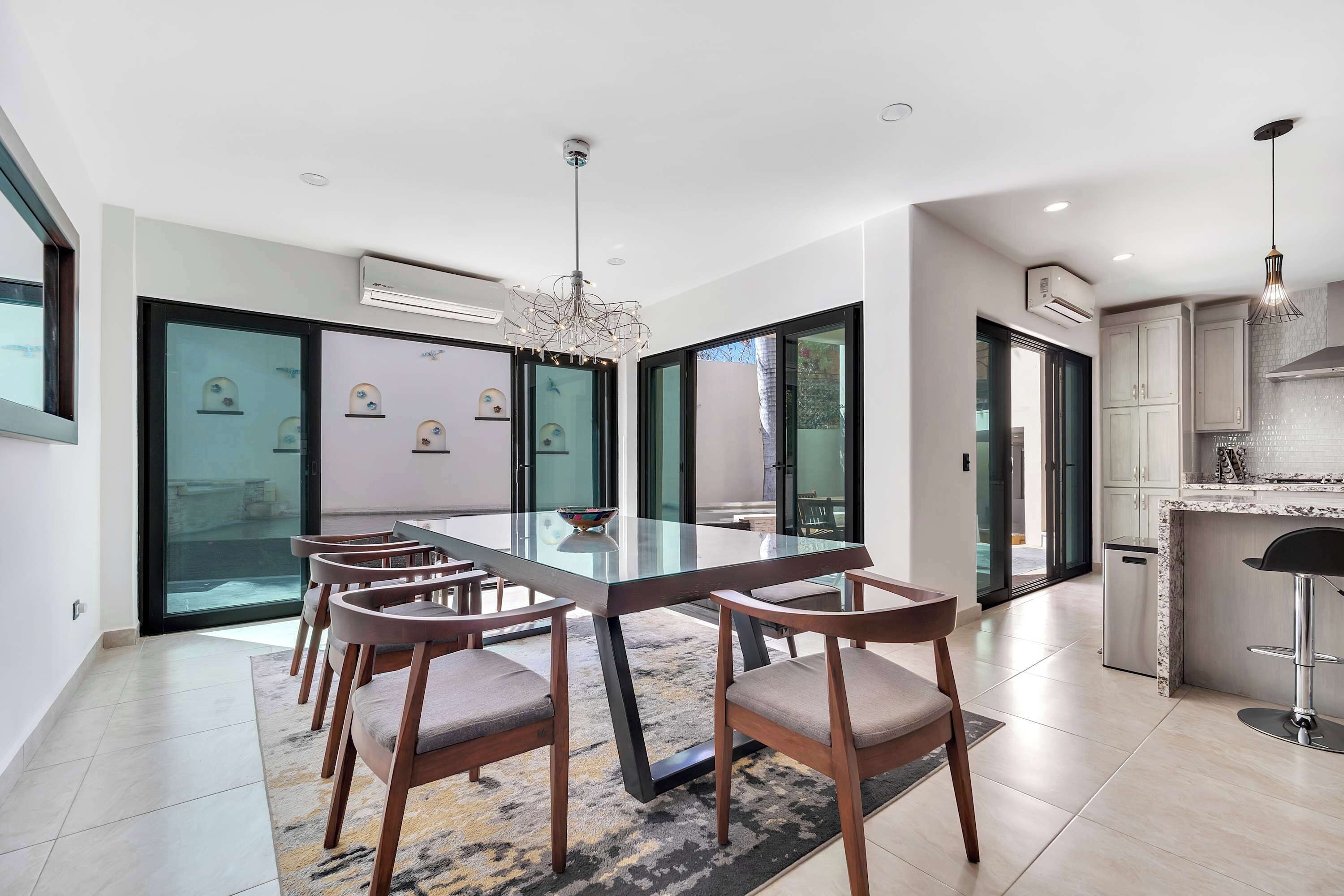 A modern kitchen with a marble countertop, stainless steel appliances, and a pendant light.