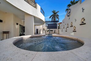 Ein Wellnessbereich mit Whirlpool, einer Pergola und einem Pool.