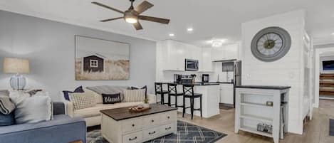 A modern living room with a sofa, coffee table, and a ceiling fan.