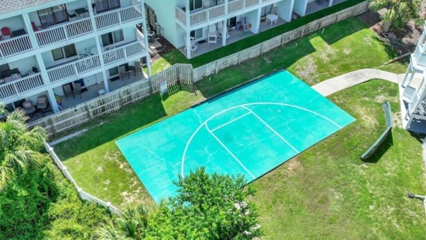 Un hotel de varios pisos con balcones, piscina y vegetación circundante.
