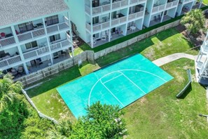 A multi-story hotel with balconies, a swimming pool, and surrounding greenery. - Seventh Heaven in Panama City (Panama City Beach)