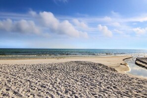 A beach with a sandy foreground and a calm sea in the background. - Seventh Heaven in Panama City (Panama City Beach)