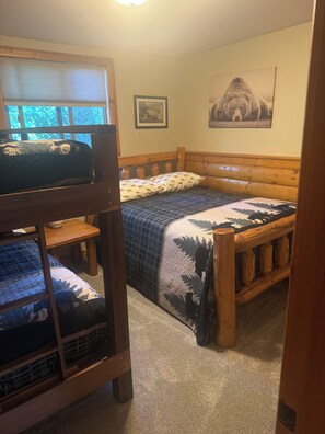 A bunk bed with a lower bunk, a wooden headboard, and a quilted bedspread. - Superb White Sand Lake home in charming Baxter with beautiful white sand beach. (Baxter)