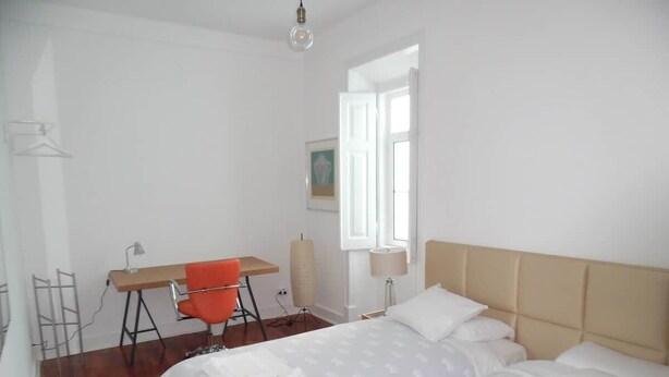 Una camera da letto con due letti, una scrivania e una sedia.