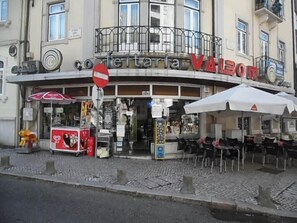 A storefront with outdoor seating, a no entry sign, and a vending machine. - Gulbenkian Park Residence Apartment (Lisbon)