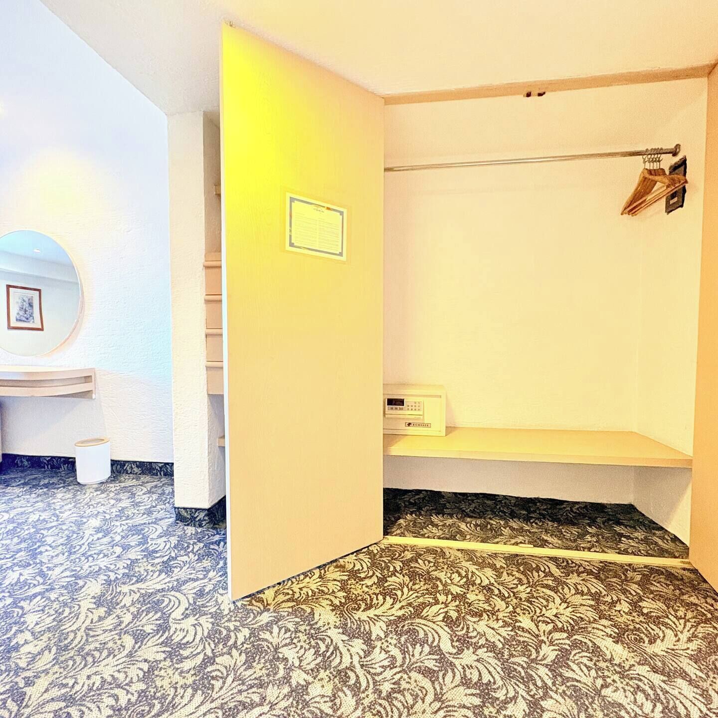 A bathroom with a toilet, a sink, a mirror, and a towel rack.