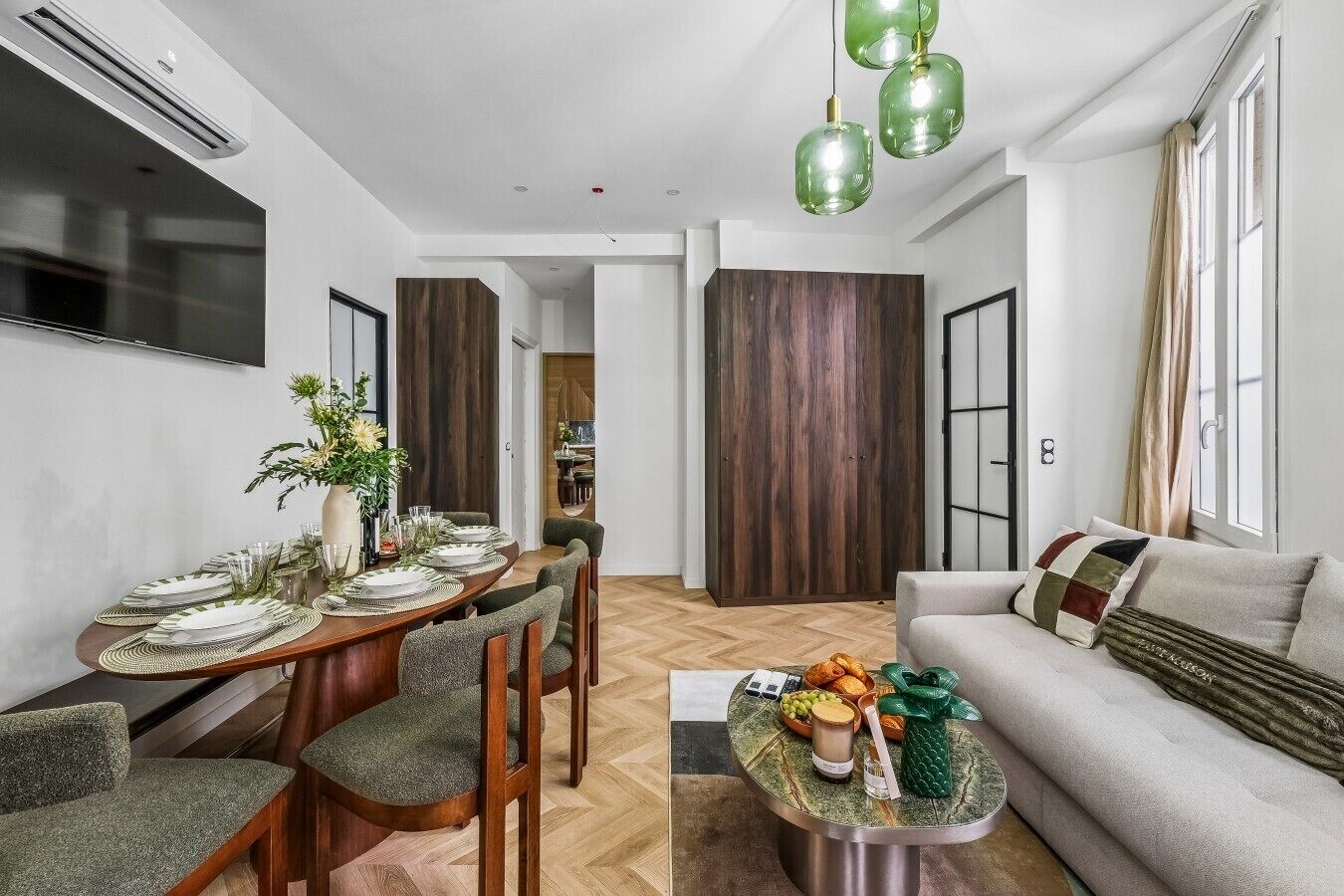 A modern living space with a dining area, a sofa, and a coffee table.