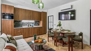 Eine moderne Küche mit Holzausstattung, einem eingebauten Ofen und einem Essbereich mit rundem Tisch und Stühlen.