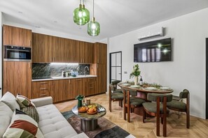 Eine moderne Küche mit Holzausstattung, einem eingebauten Ofen und einem Essbereich mit rundem Tisch und Stühlen.