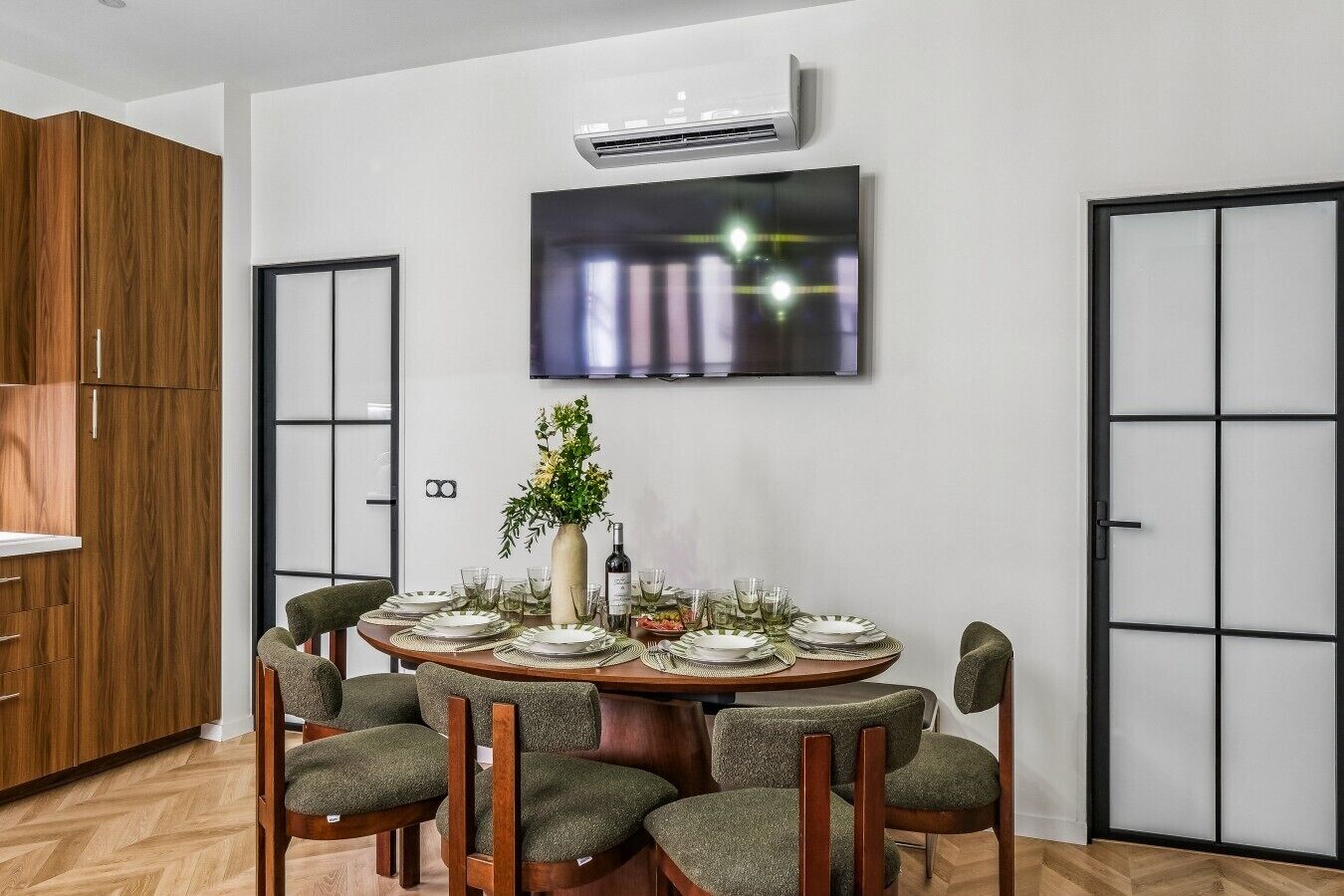 A dining area with a round table set for six, surrounded by six chairs.