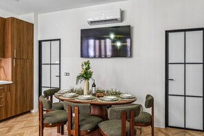 Ein Essbereich mit einem runden Tisch, gedeckt für sechs Personen, umgeben von sechs Stühlen.