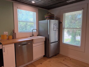 A kitchen with a stainless steel refrigerator, a sink, and wooden countertops. - Cottage beside Bert's in the Heart of Folly Beach-one block to the beach & pier! (Folly Beach)
