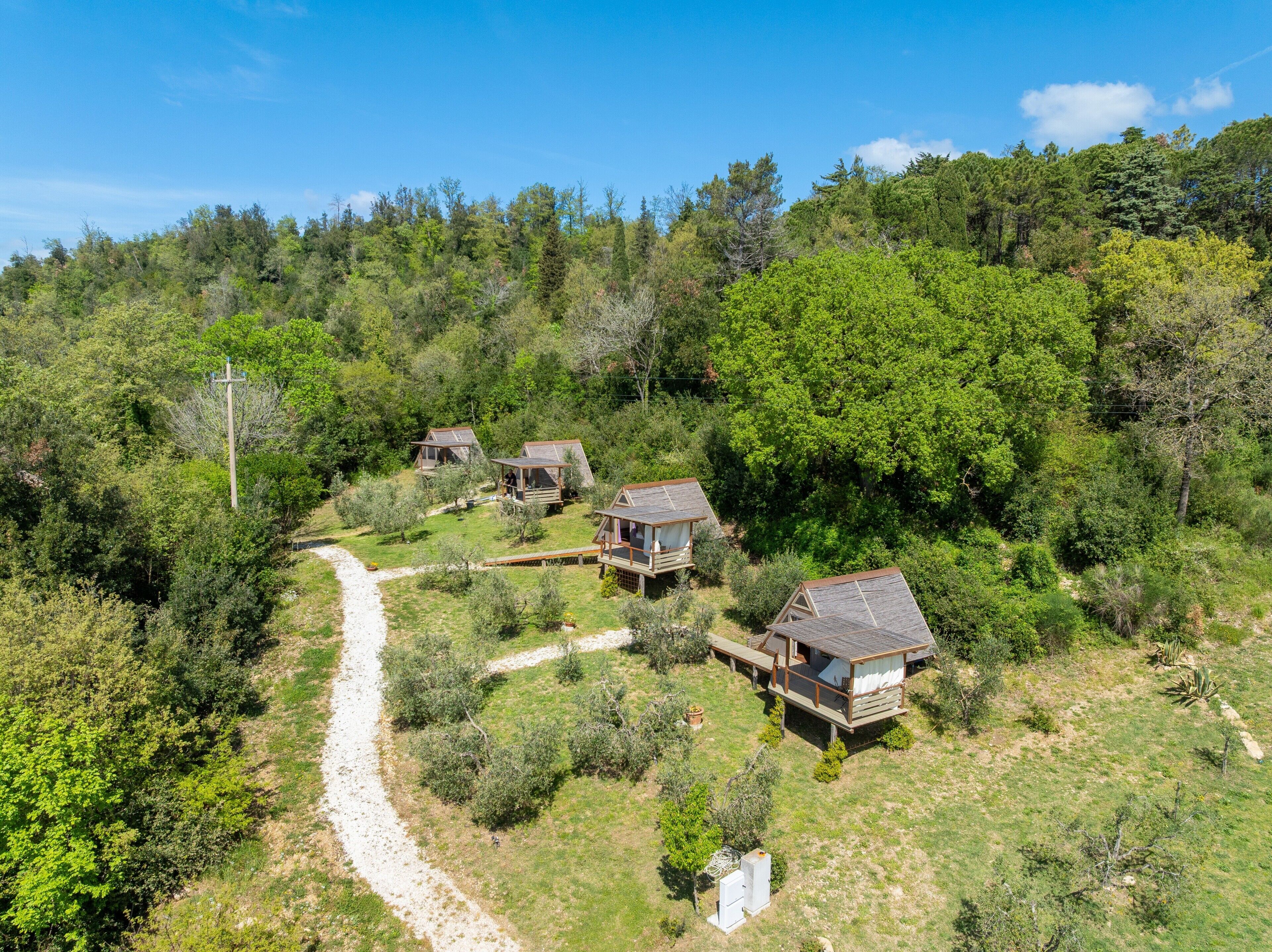 A remote, forested area with several wooden cabins.