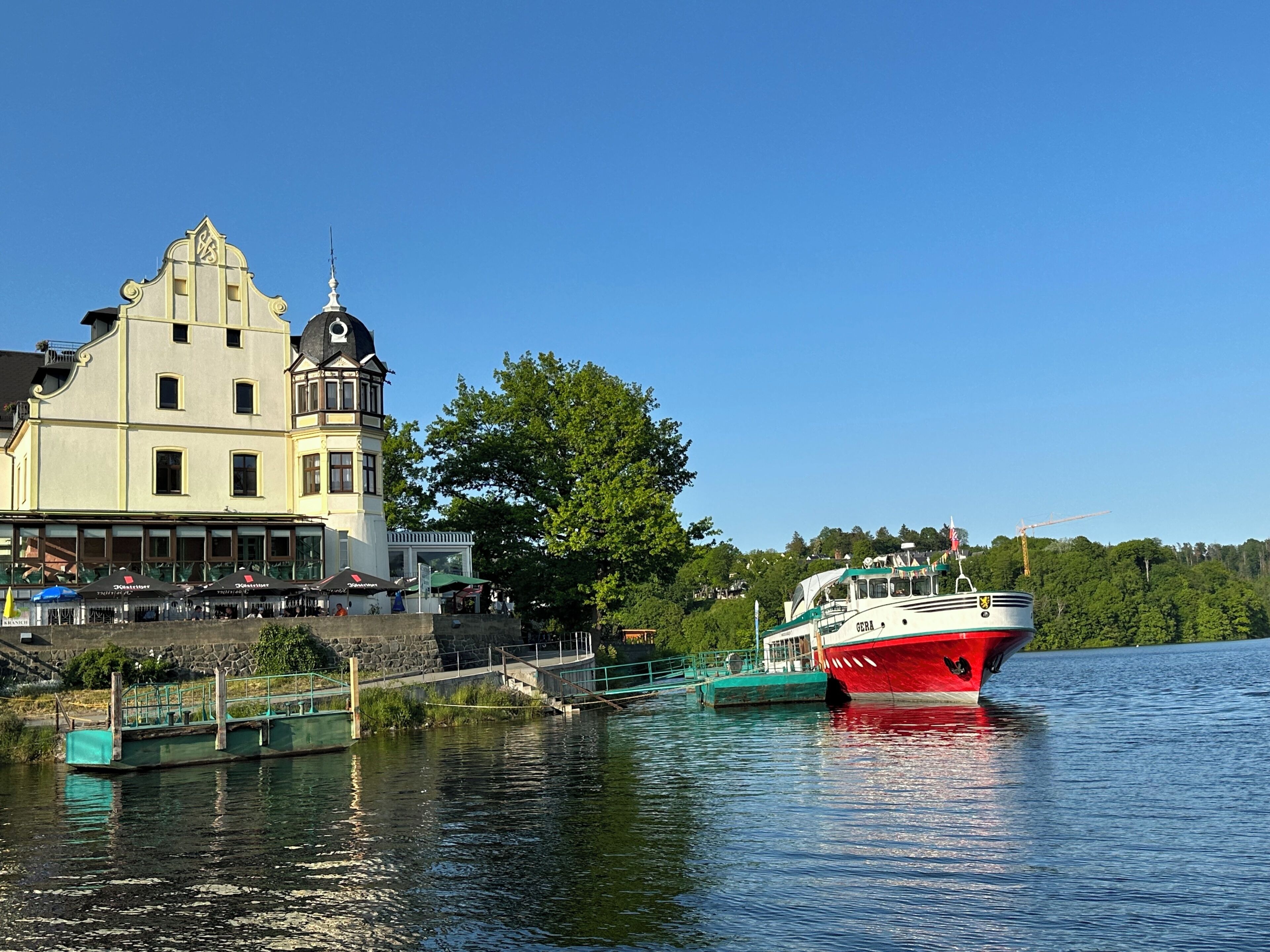 Ein historisches Gebäude mit einem Turm und einem roten Boot, das in der Nähe liegt.