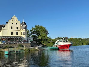 Ein historisches Gebäude mit einem Turm und einem roten Boot, das in der Nähe liegt.