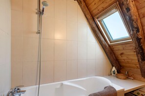 A bathroom with a sloped ceiling, a shower, a bathtub, and a skylight. - "La Grange" Gîte with Mountain View and Wi-Fi (Artalens-Souin)