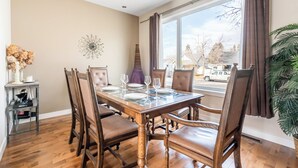 Un coin repas avec une table en bois, des chaises et un vase de fleurs.