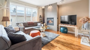 Un salon moderne avec un canapé, une table basse et un téléviseur à écran plat.